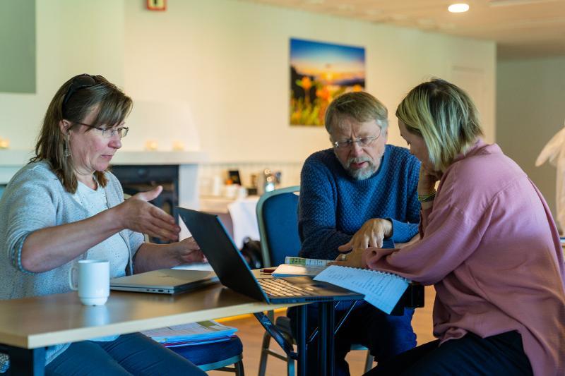 Ann Ragnhild Broderstad, Bjarne Koster Jacobsen og Susanna Siri diskuterer spørsmål som skal være med i spørreundersøkelsen knyttet til den tredje SAMINOR-undersøkelsen. Foto SSHF.jpg To kvinner og ein mann sit rundt eit bord og diskuterar.